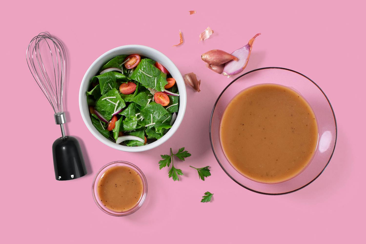overhead image of homemade balsamic vinaigrette next to a green salad and whisk attachment for the nutribullet Immersion Blender