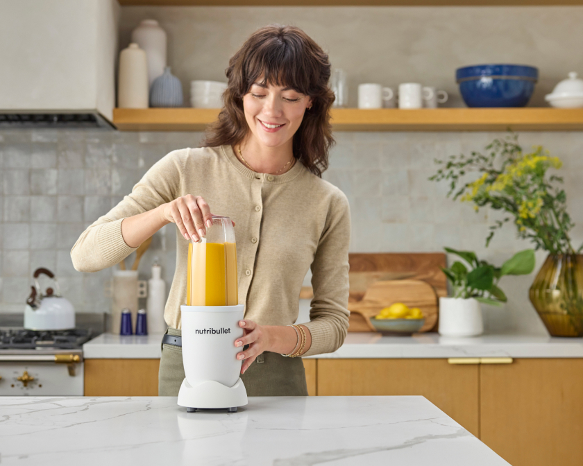 woman making yellow smoothie in her nutribullet Pro