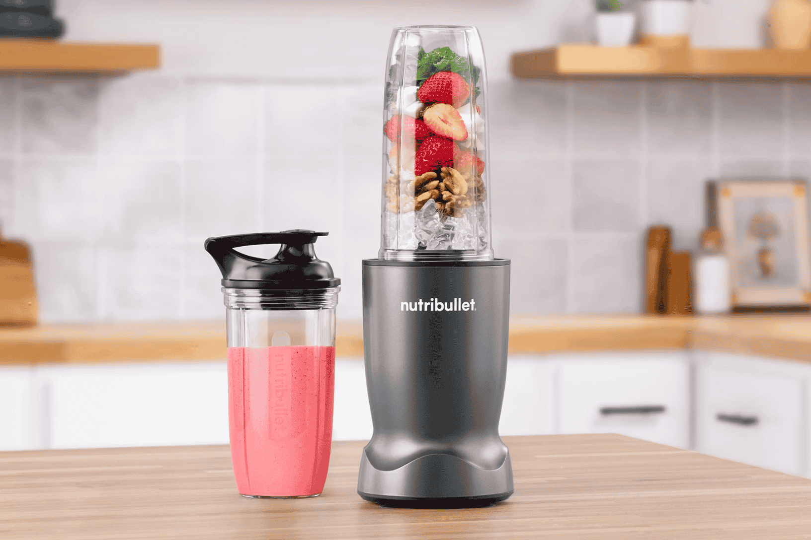 grey nutribullet personal blender with pink smoothie in a kitchen