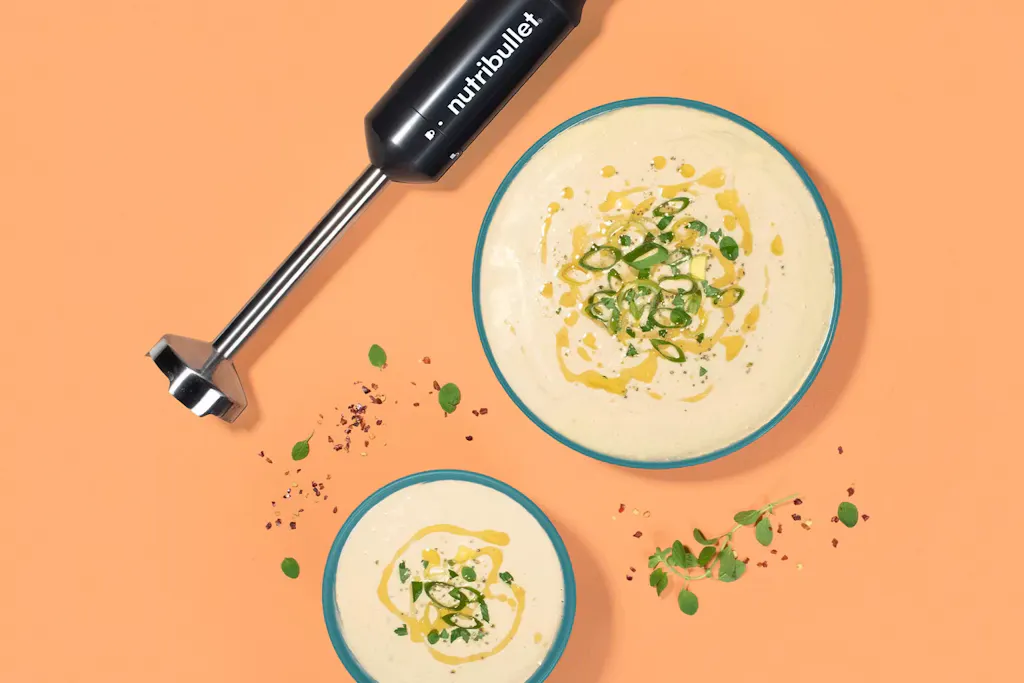 nutribullet Immersion Blender with homemade soup on an orange background