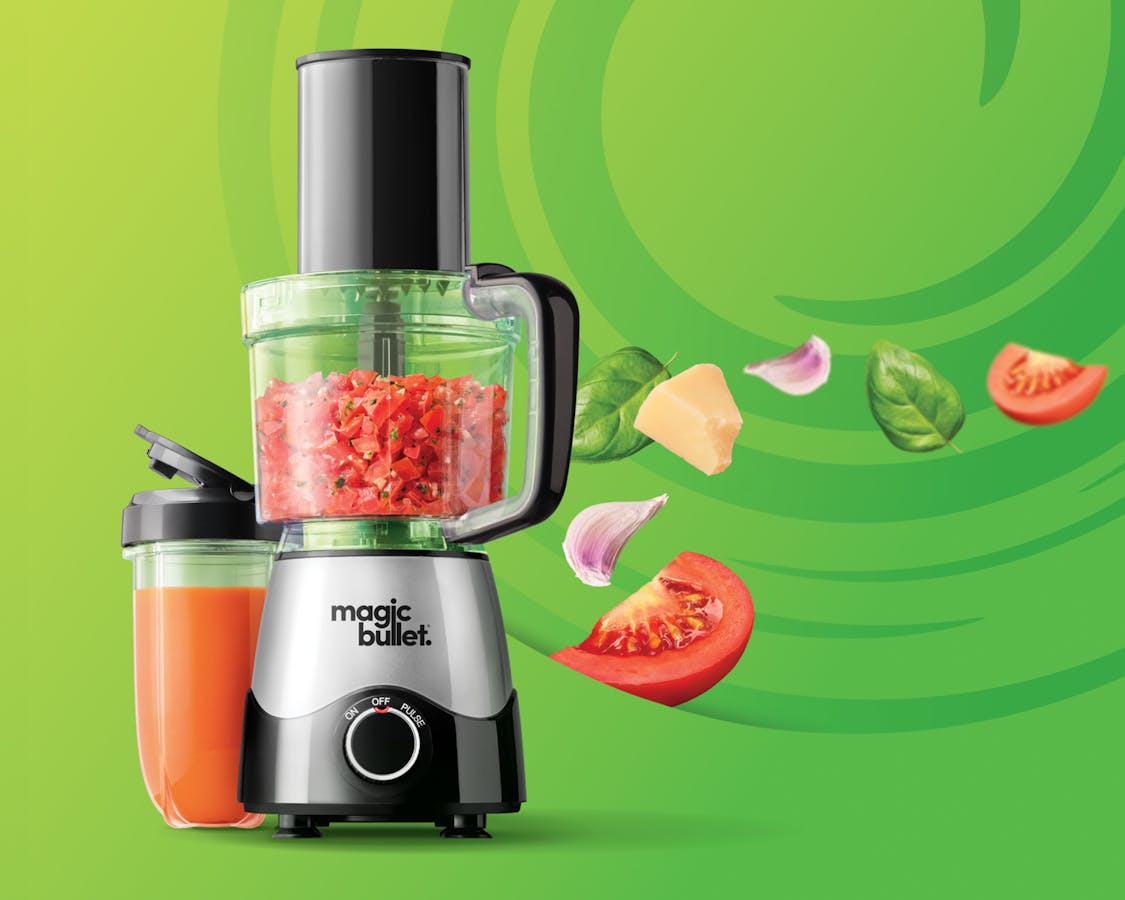 magic bullet kitchen express filled with tomatoes against a green background.