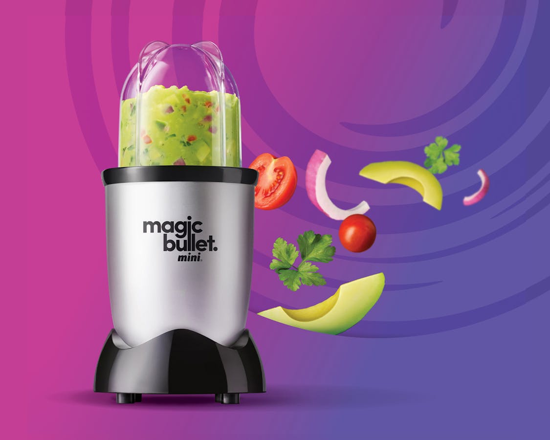 magic bullet mini filled with guacamole against a purple background.