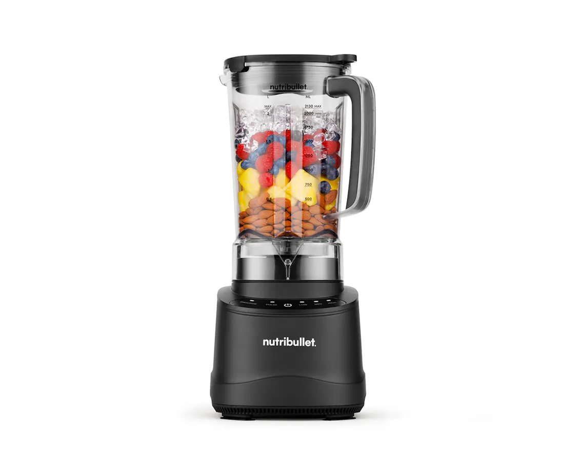 Black nutribullet Power Core XL blender with pitcher layered with almonds, pineapple, berries, and ice.