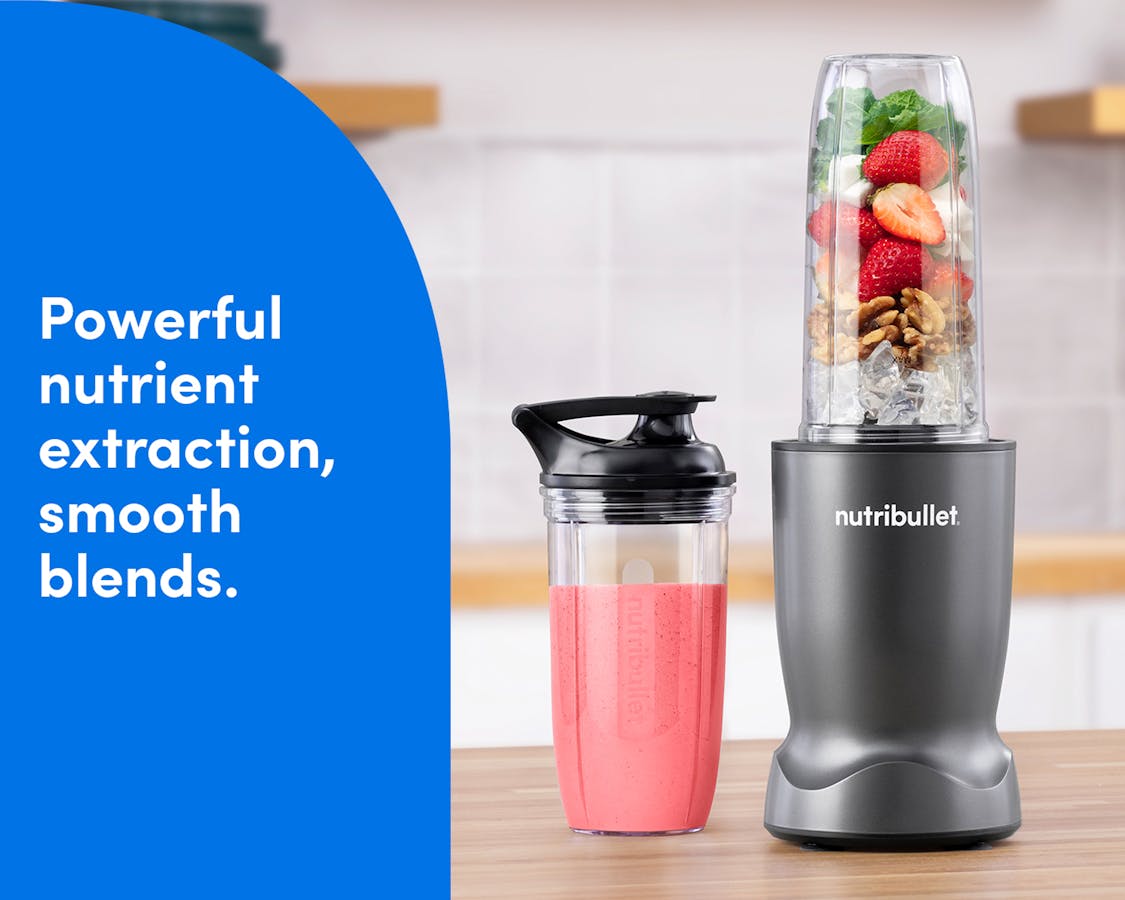 Gunmetal nutribullet Turbo blender blending fresh fruit into a smoothie alongside a to-go cup