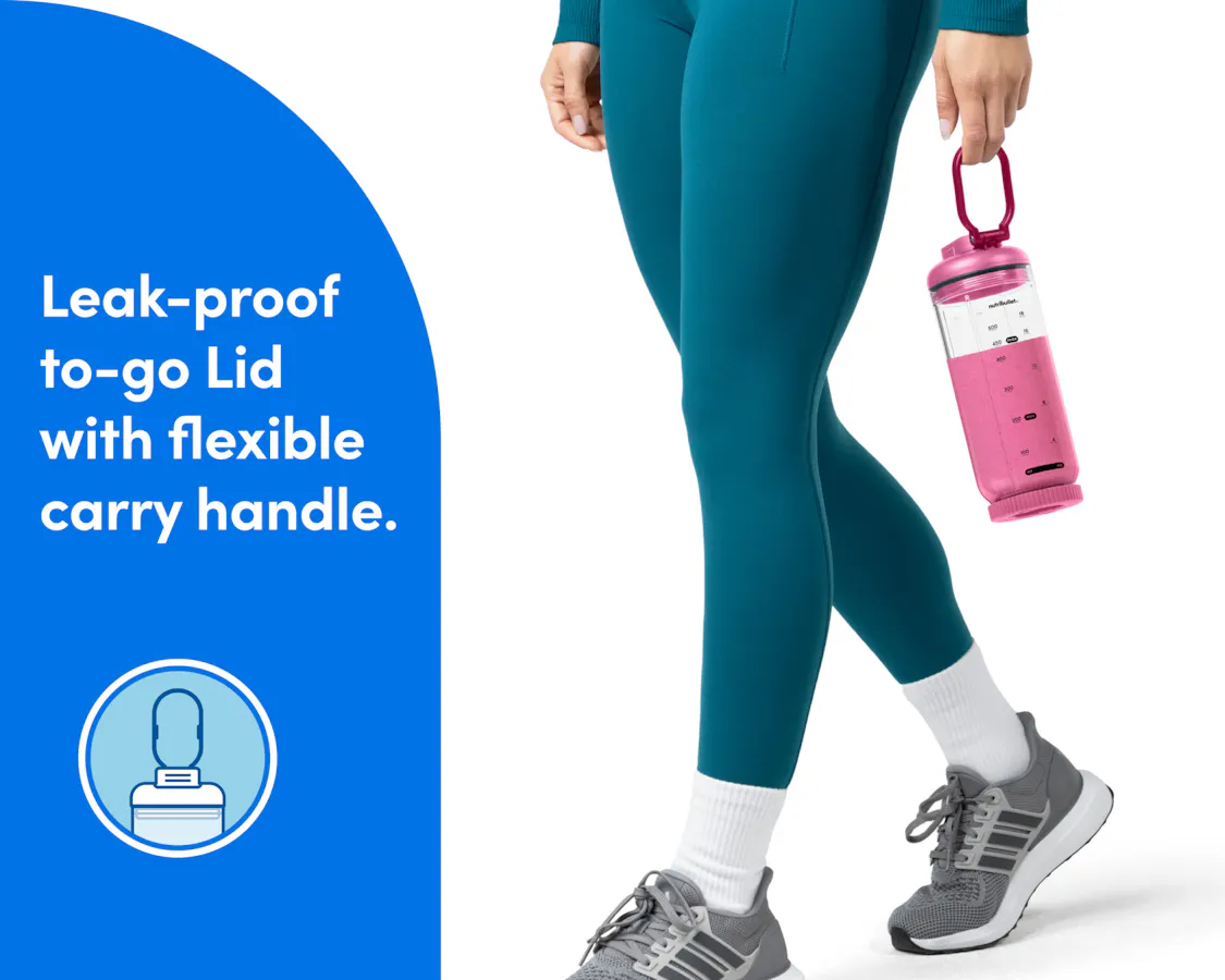 A woman's legs are shown walking in tennis shoes and teal athletic pants. Her hands are visible and she is carrying the sealed cup of the nutribullet Flex, filled with a bright pink smoothie, by the carry handle.