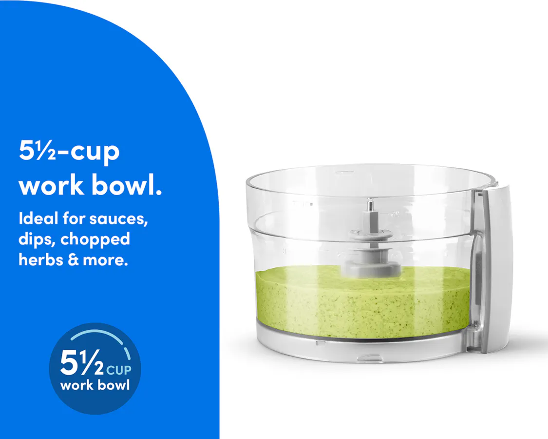 The clear work bowl of the nutribullet Limitless Food Processor filled with blended green sauce or dip.