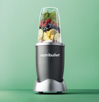nutribullet® blender fill with fruits and vegetables against a light green background