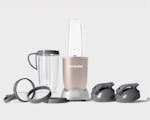 Product preview 4 of 7. Thumbnail nutribullet Champagne with 2 to-go lids, 2 32 oz. cups, 2 cup rings, and 2 handled lip rings on grey background.