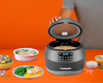 Product preview 1 of 9. Thumbnail of rice filled EveryGrain Cooker and plates and bowls of food on orange background.
