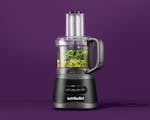 Product preview 1 of 8. Thumbnail of nutribullet® 7-Cup Food Processor with black motor base and black handle filled with green vegetables and nuts against a purple background