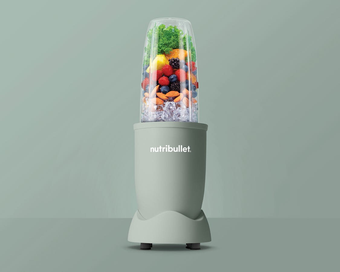 Matte jade nutribullet pro 900 filled with ice, fruits and kale.