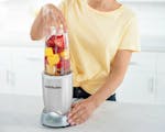 Product preview 4 of 9. Thumbnail of silver nutribullet Pro+ blender filled with fruit, greens and nuts for a smoothie.