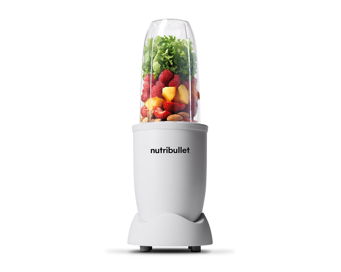 Matte white nutribullet pro 900 filled with ice, fruits and kale image.