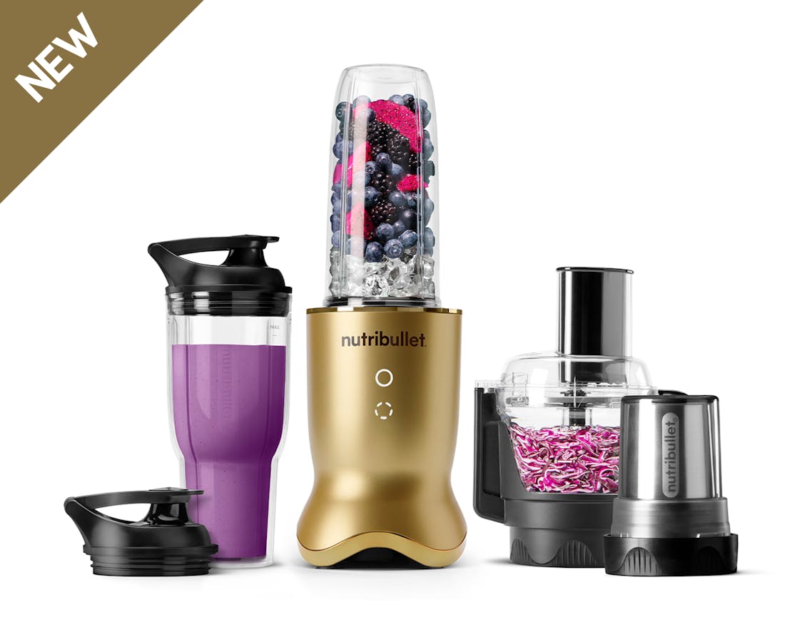 The brass-finish nutribullet Ultra Plus set with a sleek metallic base, a blending cup filled with fruits and ice, a travel cup with a lid, a food processor bowl, and a milling cup, all arranged on a white background.
