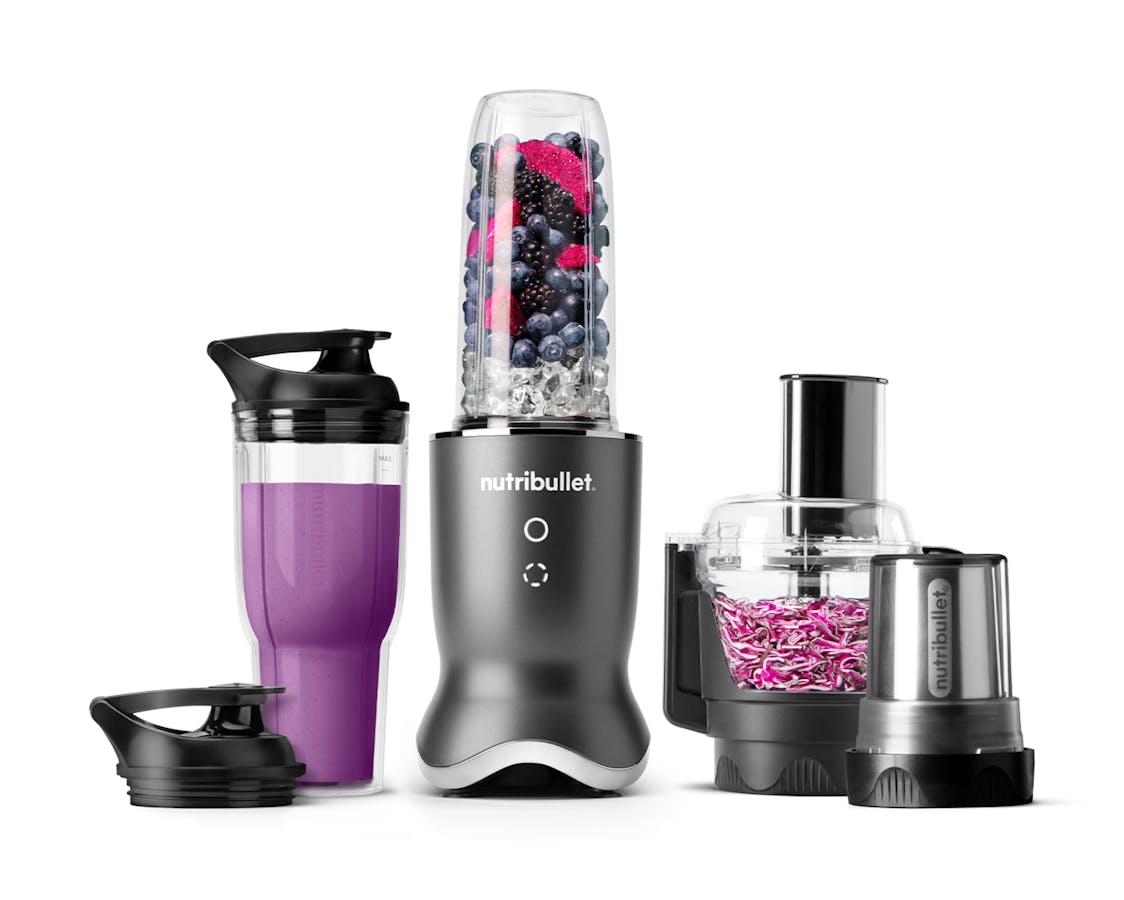 The gunmetal gray nutribullet Ultra Plus set with a sleek metallic base, a blending cup filled with fruits and ice, a travel cup with a lid, a food processor bowl, and a milling cup, all arranged on a white background.