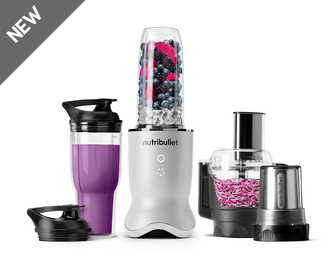 The pearl white-colored nutribullet Ultra Plus set with a sleek metallic base, a blending cup filled with fruits and ice, a travel cup with a lid, a food processor bowl, and a milling cup, all arranged on a white background.