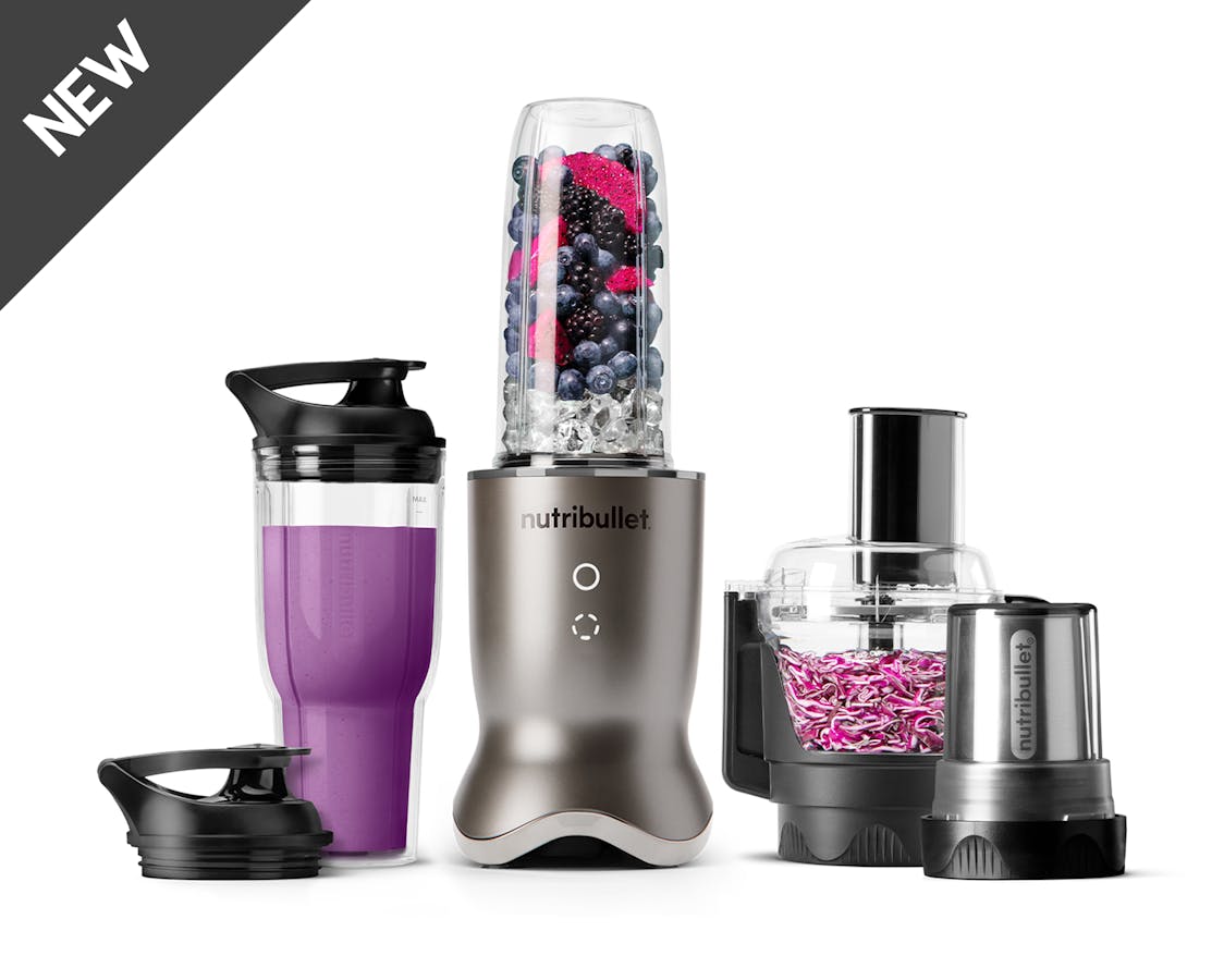 The stainless steel nutribullet Ultra Plus set with a sleek metallic base, a blending cup filled with fruits and ice, a travel cup with a lid, a food processor bowl, and a milling cup, all arranged on a white background.