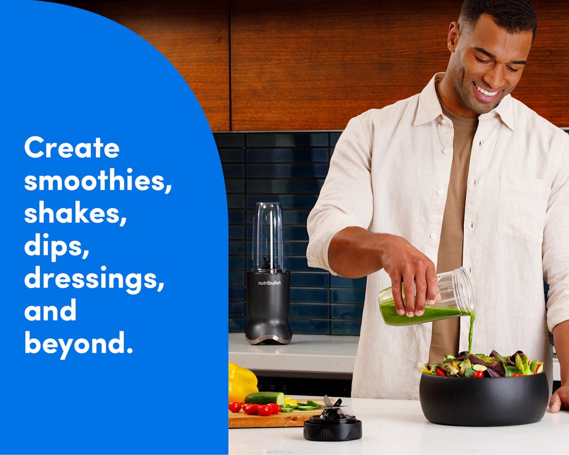 Versatile blending. A man stands behind a kitchen island and pours green salad dressing from his nutribullet Ultra cup over a bowl full of lettuce and other vegetables. The nutribullet Ultra is seen on the countertop behind the man to his left. Tex reads: create smoothies, shakes, dips, dressings, and beyond.