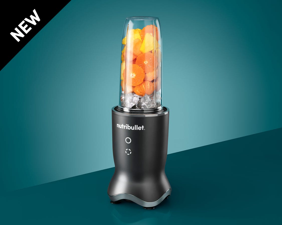 Gray nutribullet Ultra filled with ice and fruits.