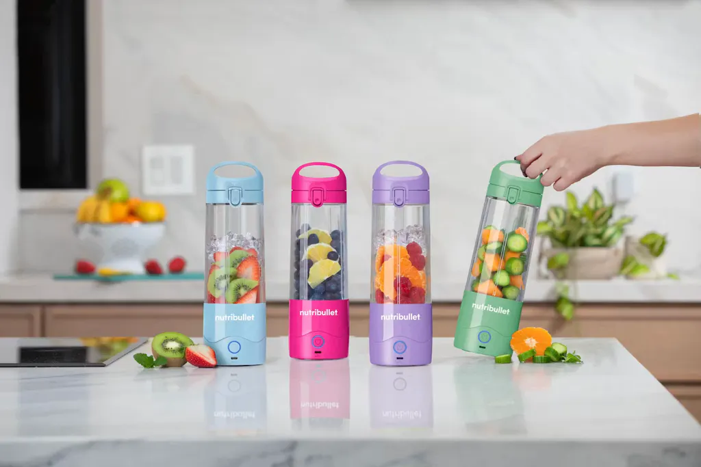 blue, pink, purple, and green nutribullet Portable Blenders filled with fresh ingredients