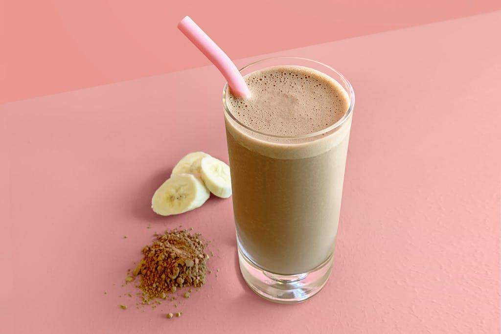 cup of chocolate peanut butter smoothie with banana and cacao powder