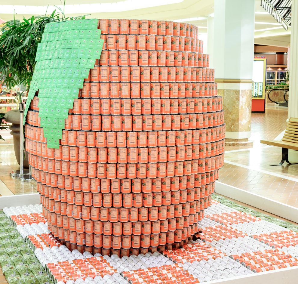 orange ad green cans shaping a large orange sculpture