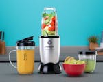 Product preview 1 of 4. Thumbnail magic bullet with vegetables and cups of juice and guacamole on blue background.