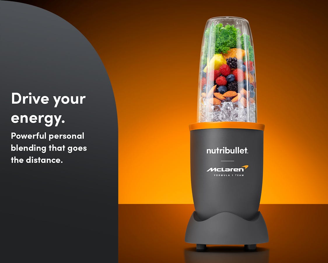 The nutribullet® x McLaren: Pro with fresh fruit, nuts and ice on an orange and black background. A gray panel on the left reads "Drive your energy".