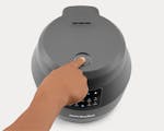 Product preview 4 of 9. Thumbnail of gray EveryGrain Cooker lid closed with hand pressing open button.