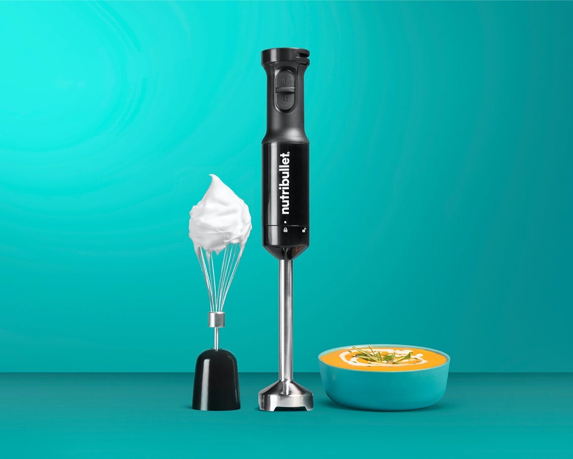 NEW Black Immersion Blender whisk attachment with cream on tip next to handle with recipe in bowl on blue background.