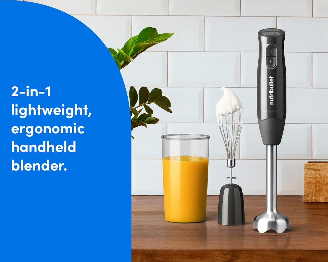 2-in-1 Lightweight Handheld Blender A nutribullet Lite handheld blender displayed on a kitchen counter beside a whisk, blending cup, and plant, emphasizing its compact, 2-in-1 design.
