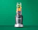 Product preview 1 of 7. Thumbnail nutribullet with fruits, vegetables, and nuts on green background.