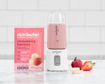 Product preview 3 of 10. Thumbnail of strawberry banana Ready-To-Blend Smoothie packet with white nutribullet GO filled with smoothie.
