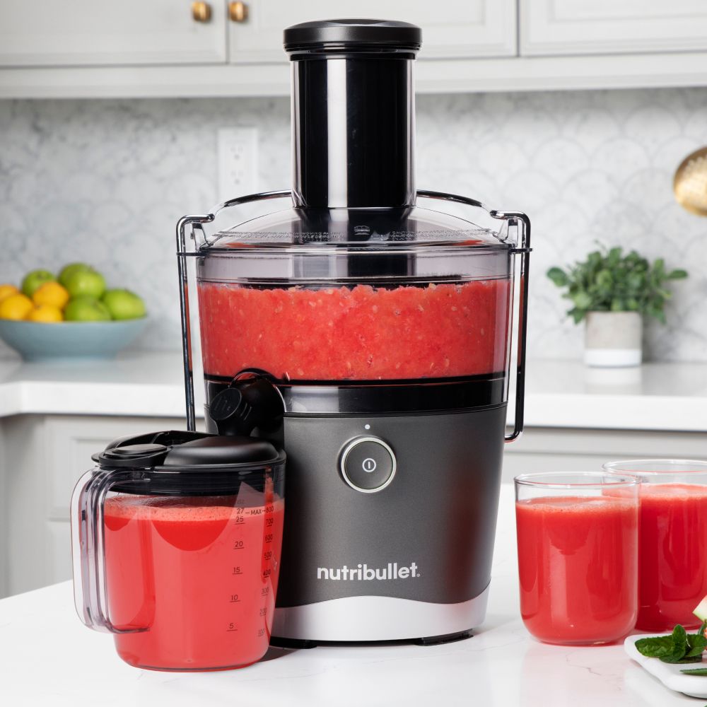 nutribullet gray juicer on a kitchen countertop with freshly made watermelon juice